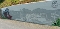 Graffiti an einer Mauer zeigt eine Dampflokomotive links und eine stilisierte Landschaft mit Gebäuden und Bergen rechts, rechts oben das Logo und der Schriftzug 'BSW-HOTEL LINDENBACH'
